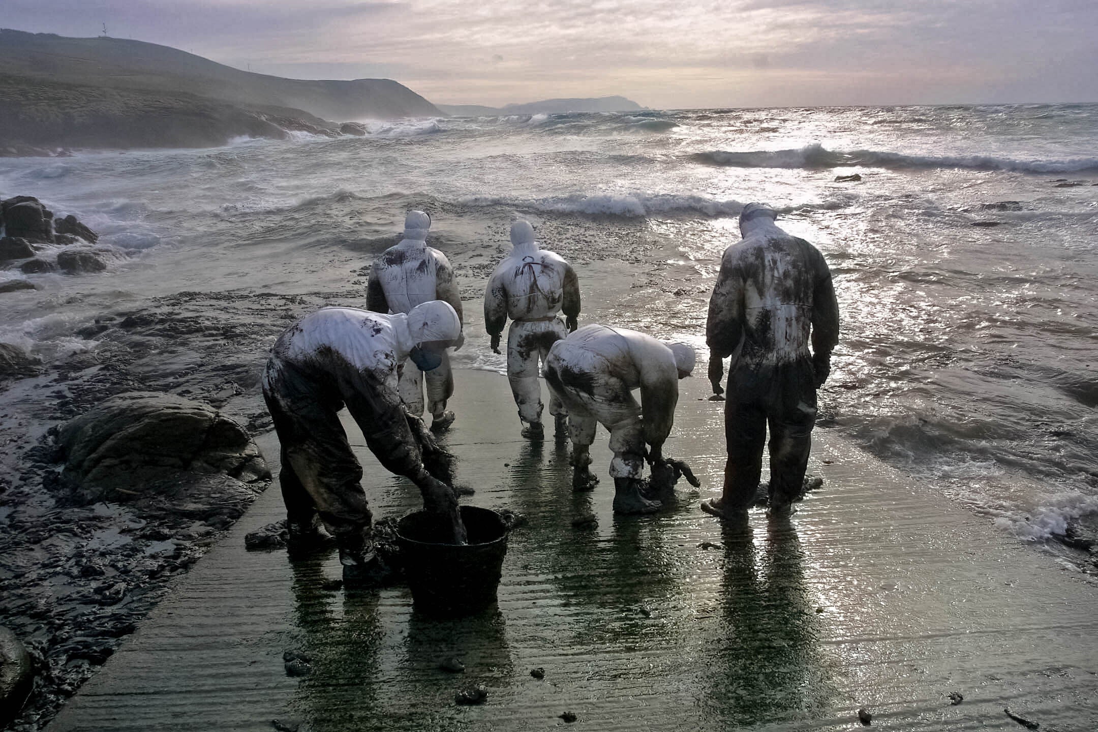  Operativos del ejército español ayudan en las labores de limpieza de petróleo en la costa de Touriñán, en la localidad gallega Muxía, el 11 de noviembre de 2002 después de que la marea arrastrare el chapapote hacia la costa gallega tras el derrame provocado por el hundimiento del buque petrolero Prestige