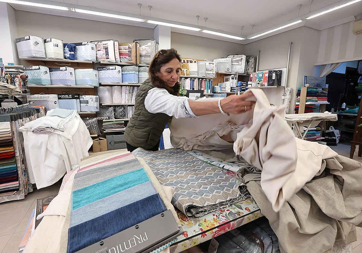 Una mujer muestra las existencias de su tienda en Córdoba