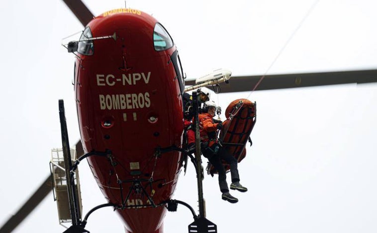 Imagen principal - Sobre estas líneas, distintos momentos de un simulacro de rescate en la sierra madrileña esta semana, desde la preparación del agente a la recuperación del cuerpo y su traslado