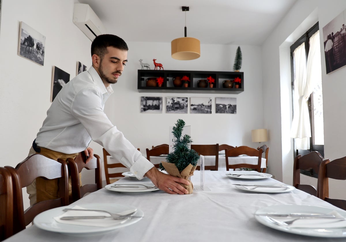 Un camarero prepara una mesa para una comida de navidad en un restaurante de Córdoba