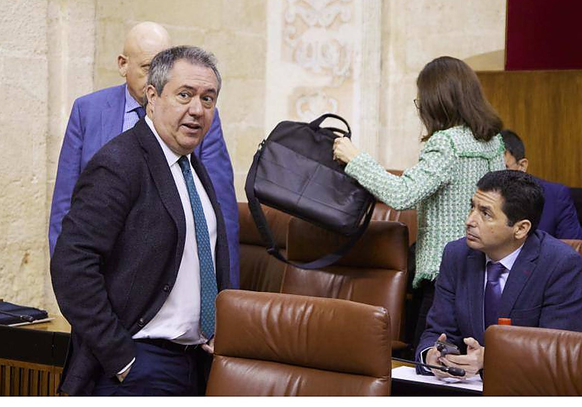 El secretario general del PSOE andaluz, Juan Espadas, conversa desde su escaño con Rafael Recio