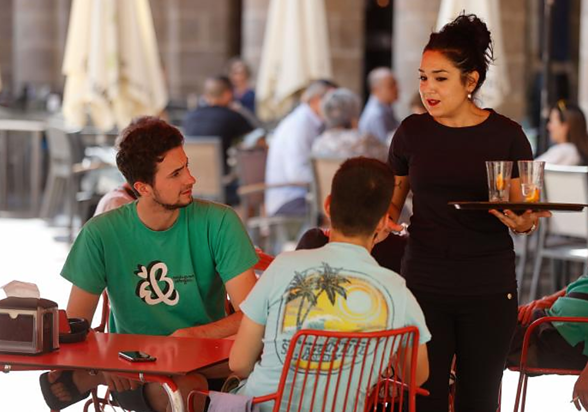 Una empleada de restauración atiende una mesa en Bilbao en foto de archivo