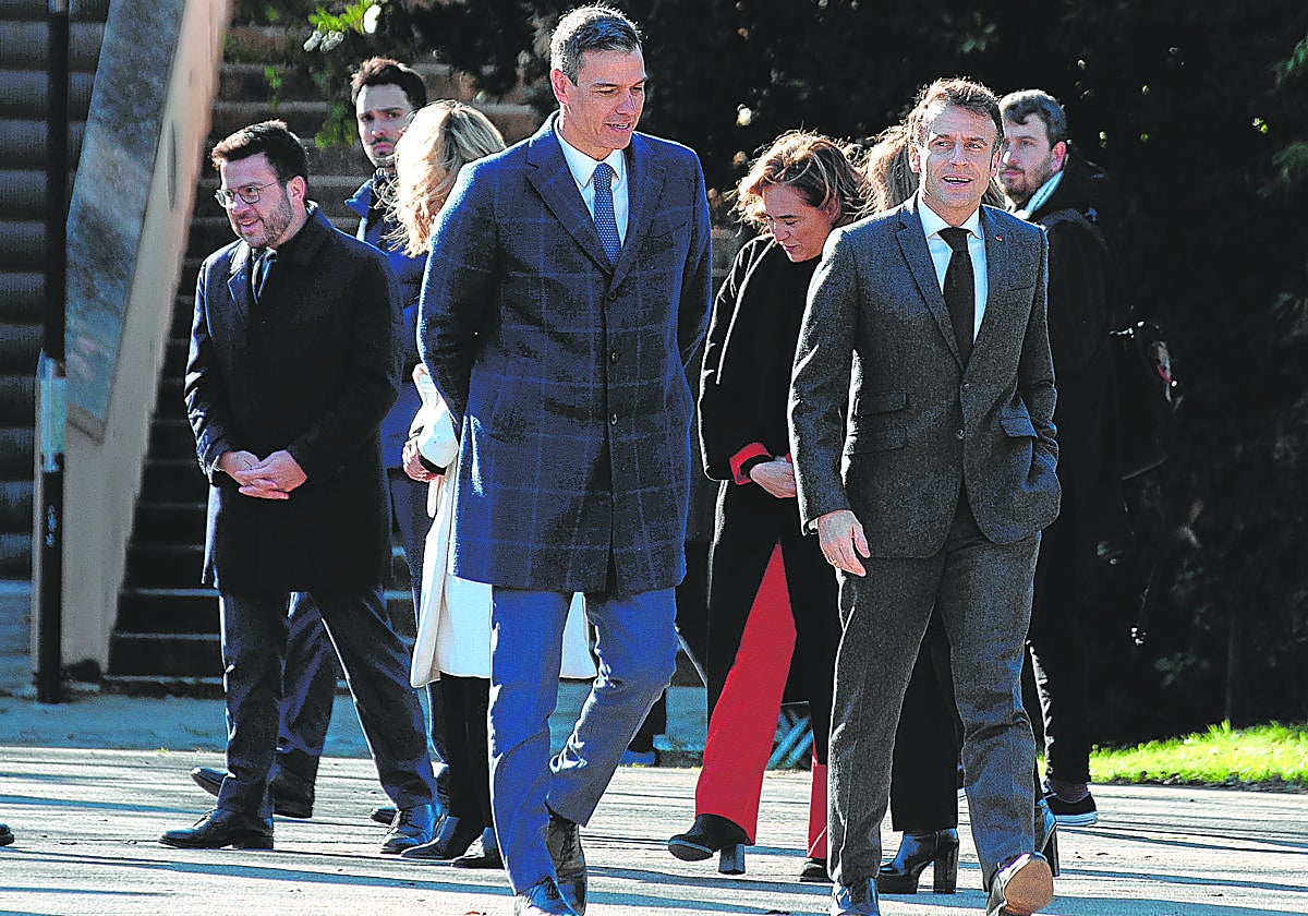 Momento en el que Aragonès (izq.) abandona la cumbre hispano-francesa antes de que sonasen los himnos y tras saludar a Sánchez y Macron (dcha.)