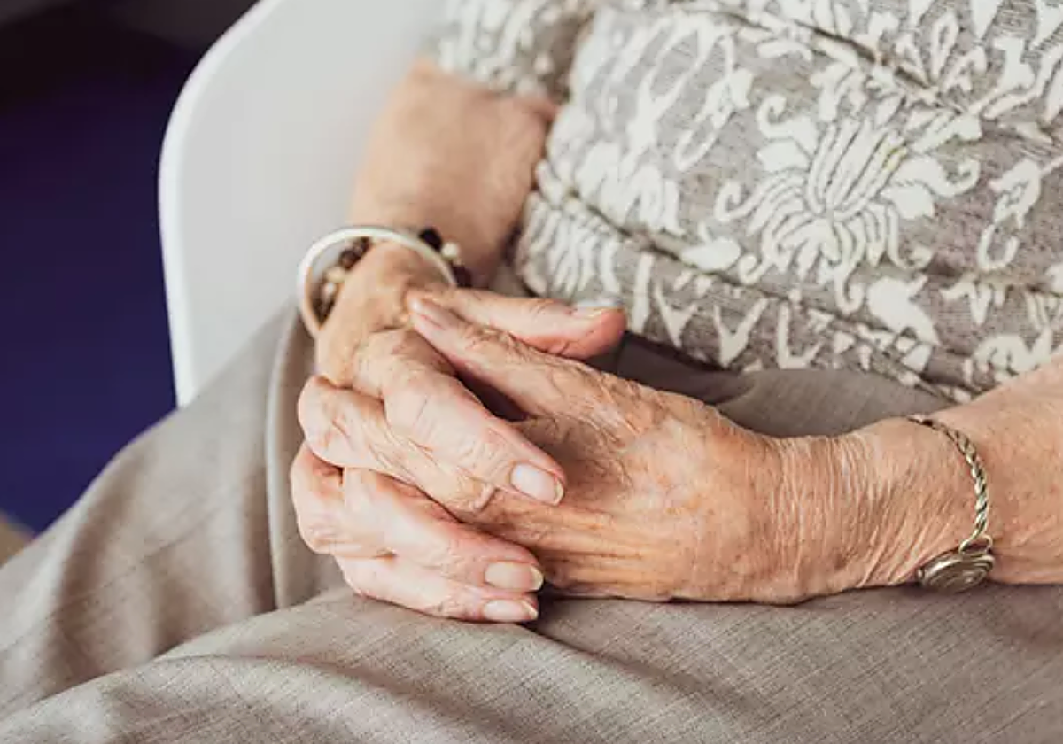 Una mujer mayor en una residencia en foto de archivo