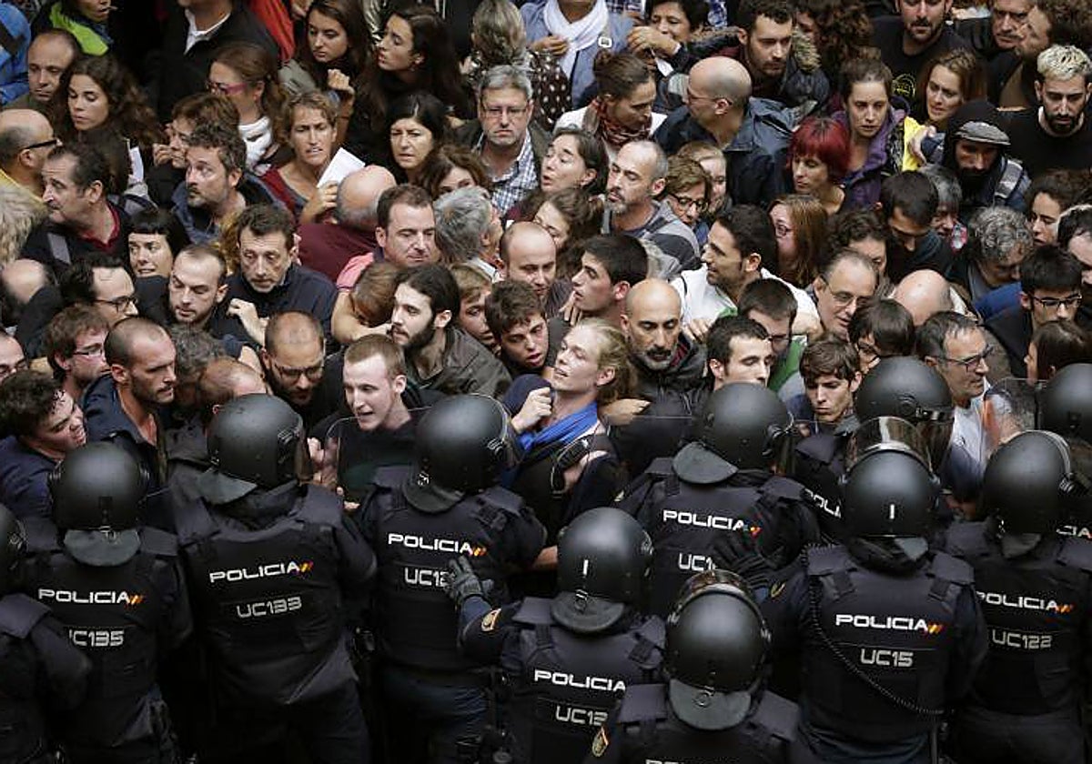 Antidisturbios de la Policía Nacional forman un cordón en los alrededores del colegio Ramón Llull de Barcelona el 1-O