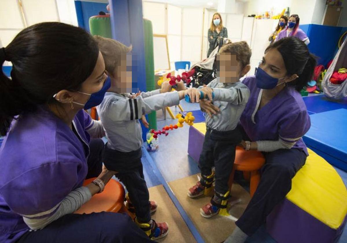 Una profesional atiende a un pequeño en un centro de atención temprana