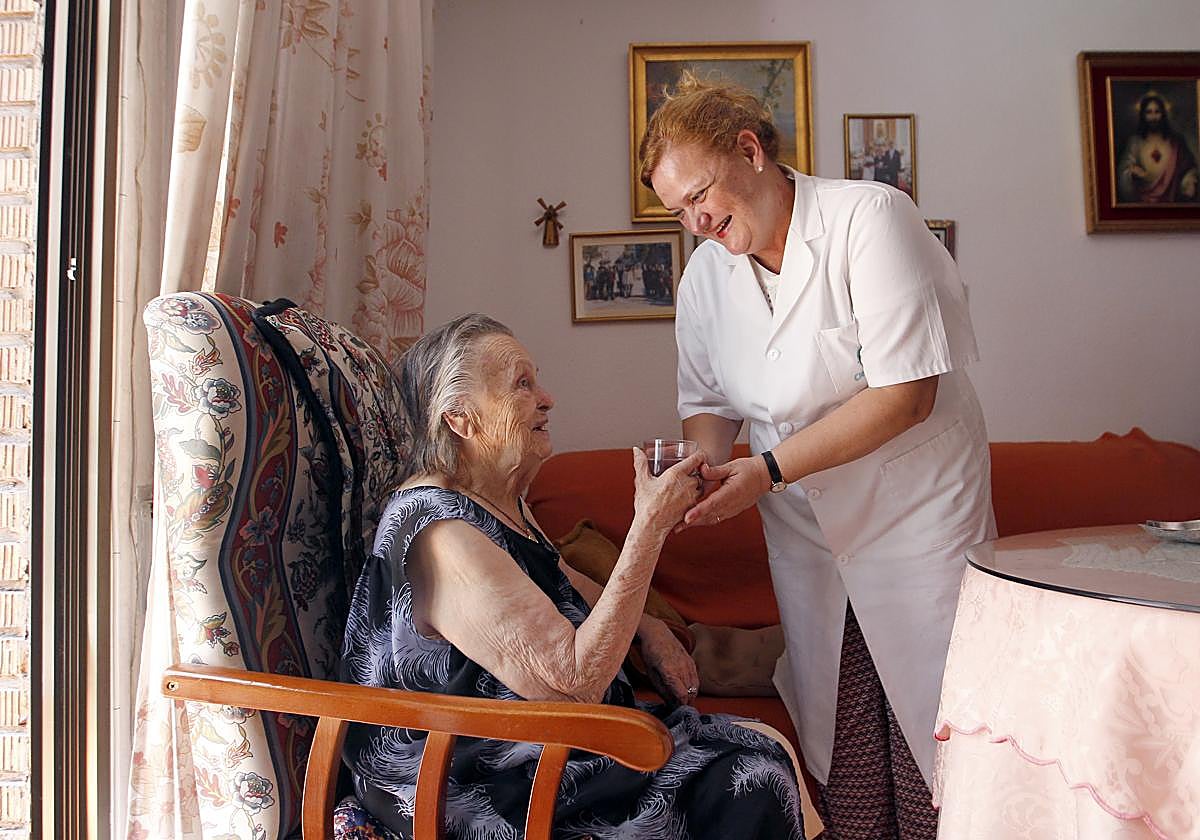 Una trabajadora asiste a una usuaria de ayuda a domicilio