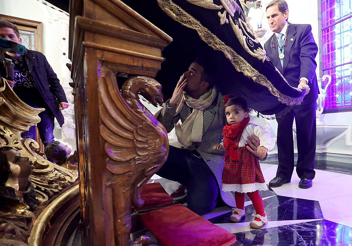 Una niña, junto a su padre, bajo el manto de la Virgen de los Dolores, este jueves