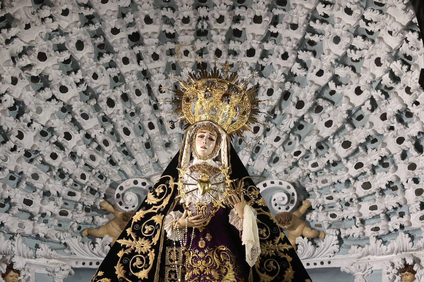 Los niños pasan bajo el manto de la Virgen de los Dolores de Córdoba, en imágenes