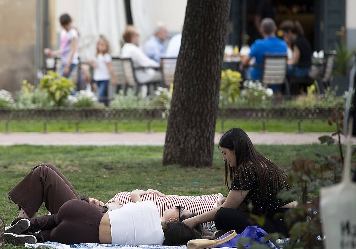 Un grupo de jóvenes dialoga tranquilamente en un parque madrileño durante la primavera de 2022