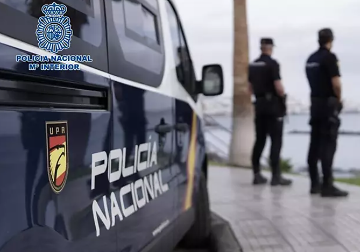 Agentes y coche patrulla en foto de archivo