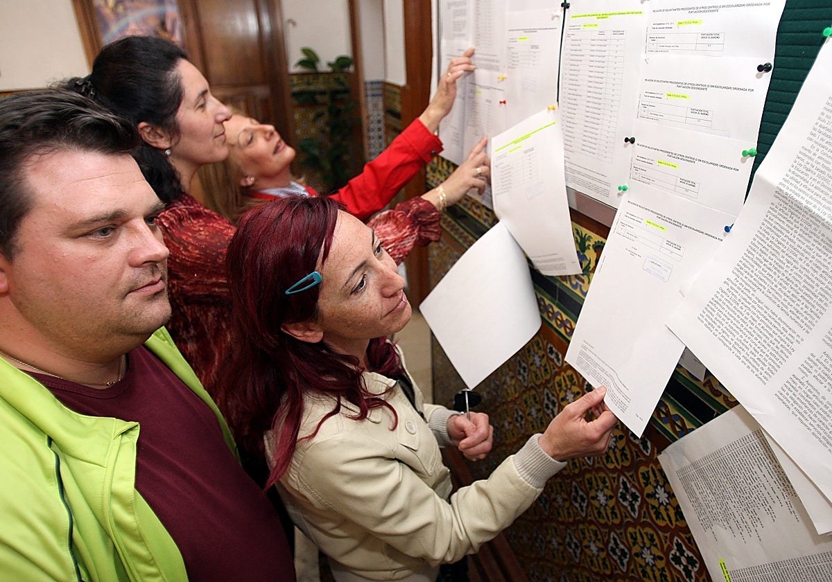 Padres consultan las listas publicadas en un colegio con la admisión de alumnos