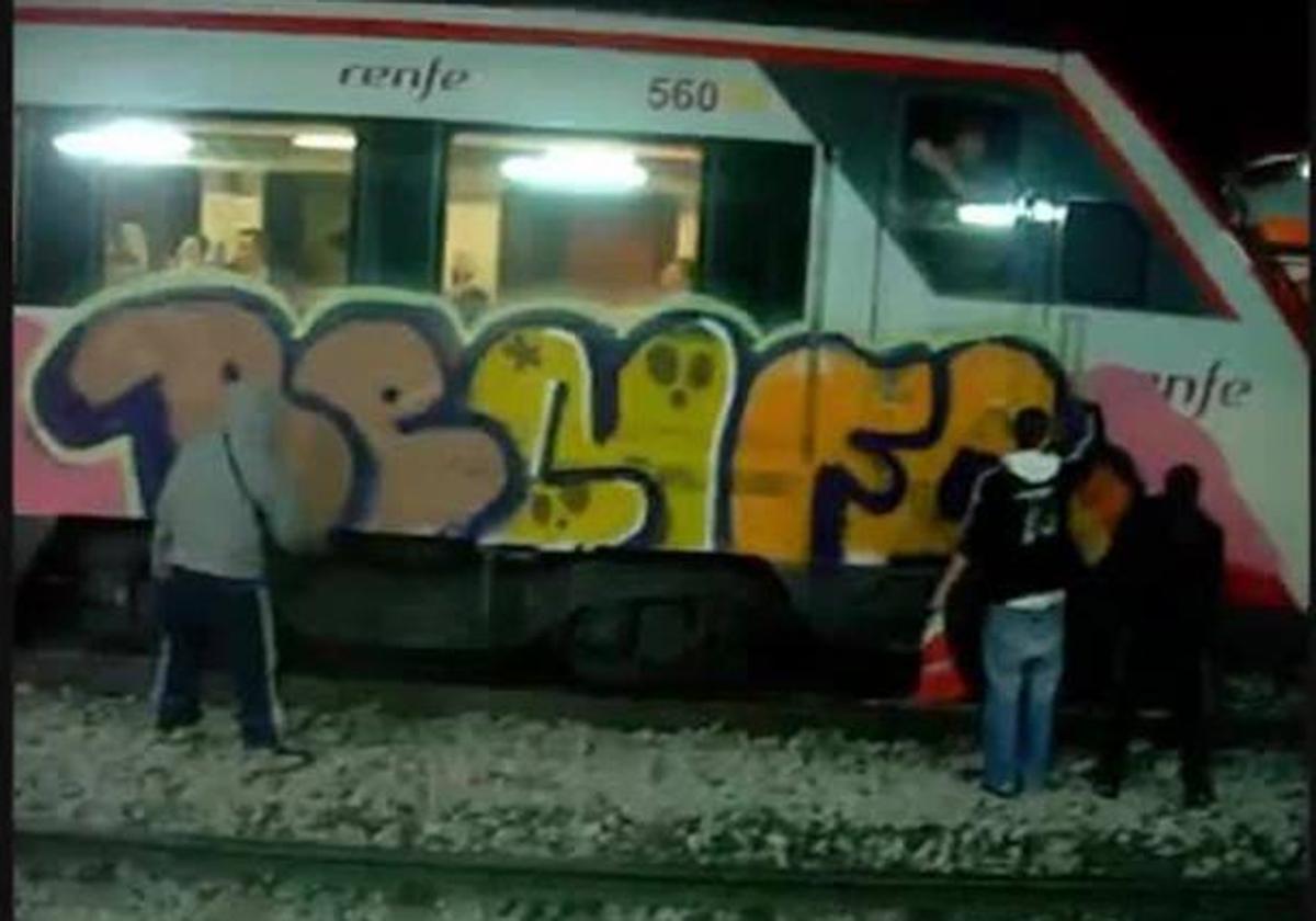 Unos grafiteros pintando los vagones de un tren de Renfe en una imagen de las cámaras de seguridad de la compañía