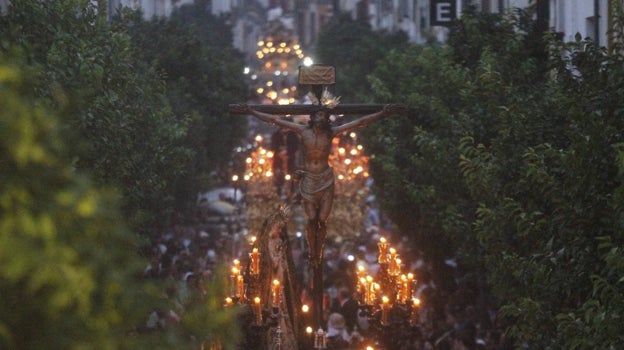 El Cristo de la Expiración avanza por la calle San Fernando, con muchos otros pasos detrás