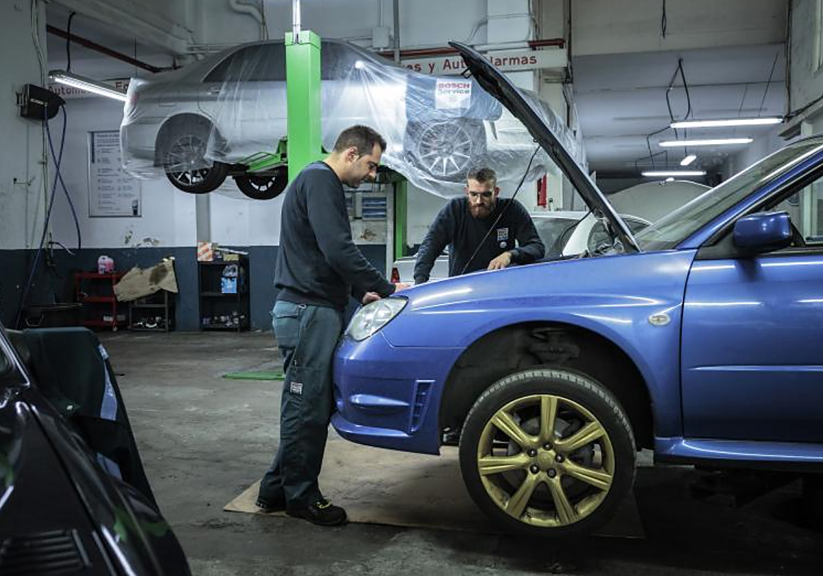 Trabajadores de un taller de coche en foto de archivo