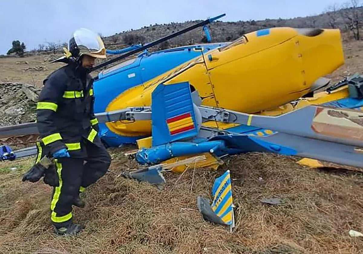 un bombero, junto al helicóptero destrozado