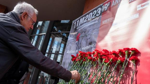 Un hombre deposita flores durante la ofrenda floral durante el acto de aniversario del 11-M en el monumento a las víctimas de Atocha