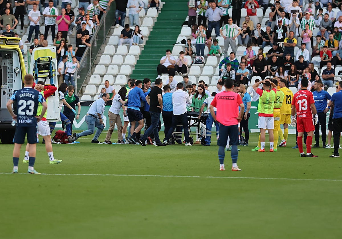 Los servicios médicos suben a la camilla a Gudelj que estaba tendido sobre el terreno de juego