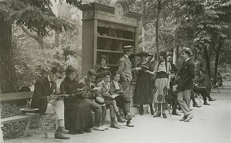 Imagen principal - Arriba, agosto de 1921, lectores en torno a una de las primeras bibliotecas circulantes abiertas en El Retiro. Abajo, izquierda, niñas viendo comics en el parque; derecha, dos mujeres con sendos ejemplares en una de las bibliotecas del parque.