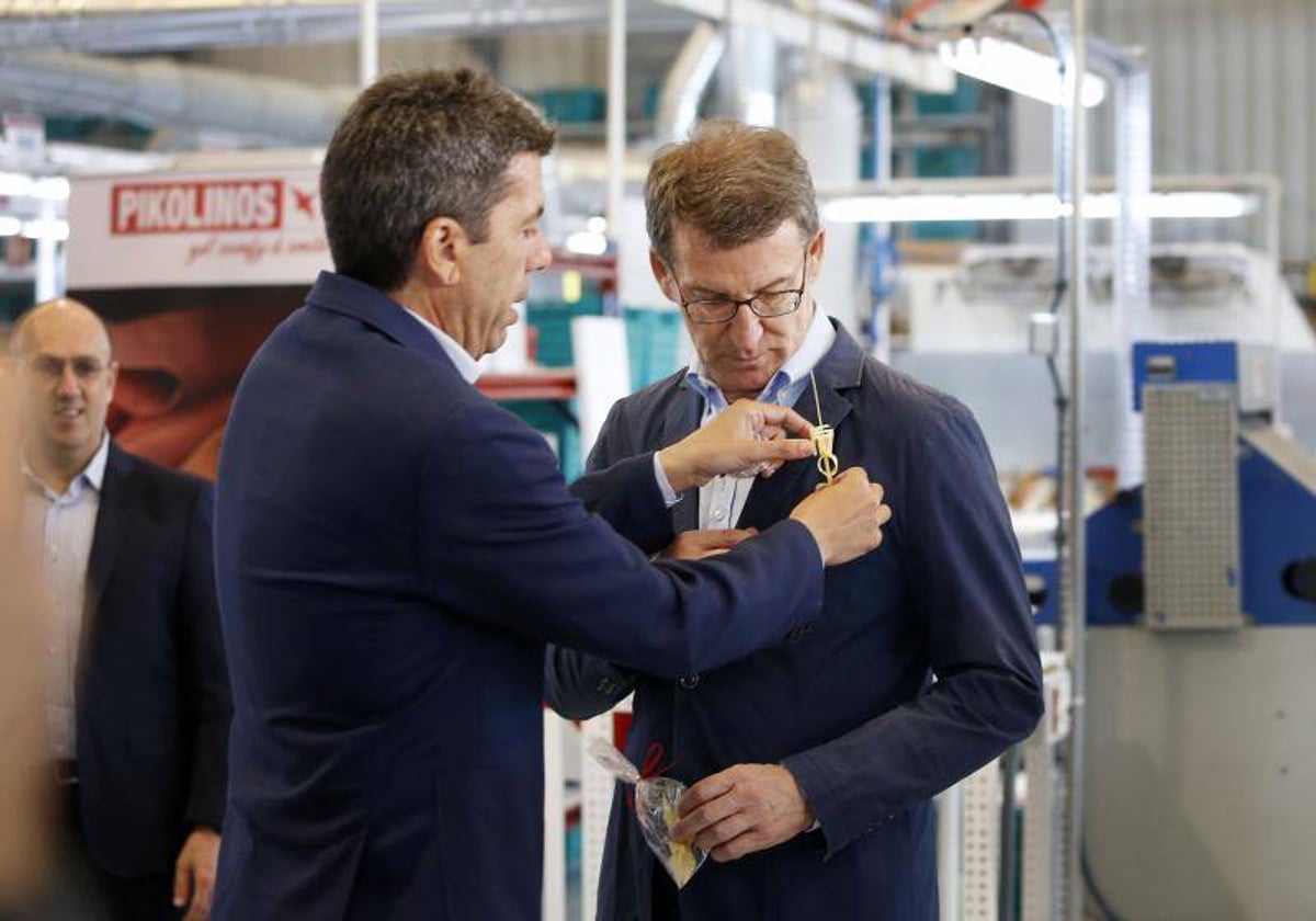 Carlos Mazón coloca un broche de una palma de Semana Santa de Elche a Feijóo durante su visita a esa ciudad