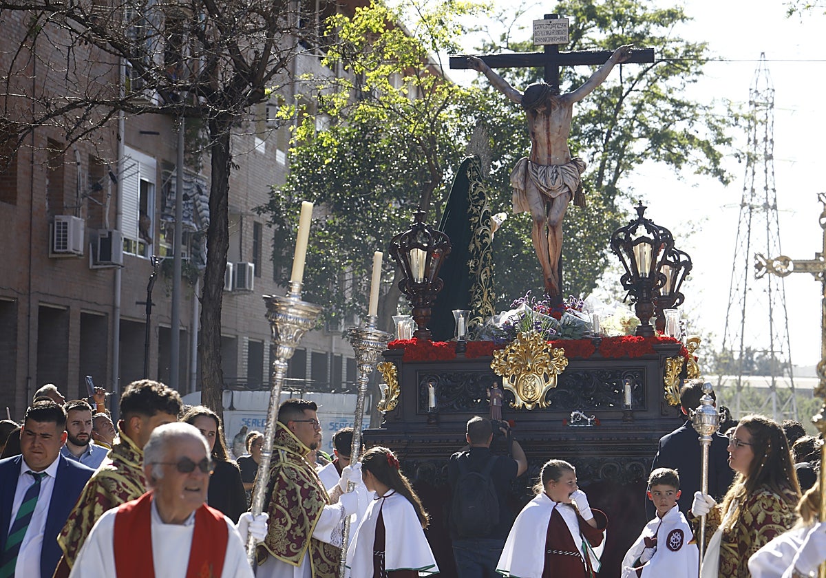 El Cristo de la Piedad en una de las calles del barrio de Las Palmeras a los pocos minutos de su salida