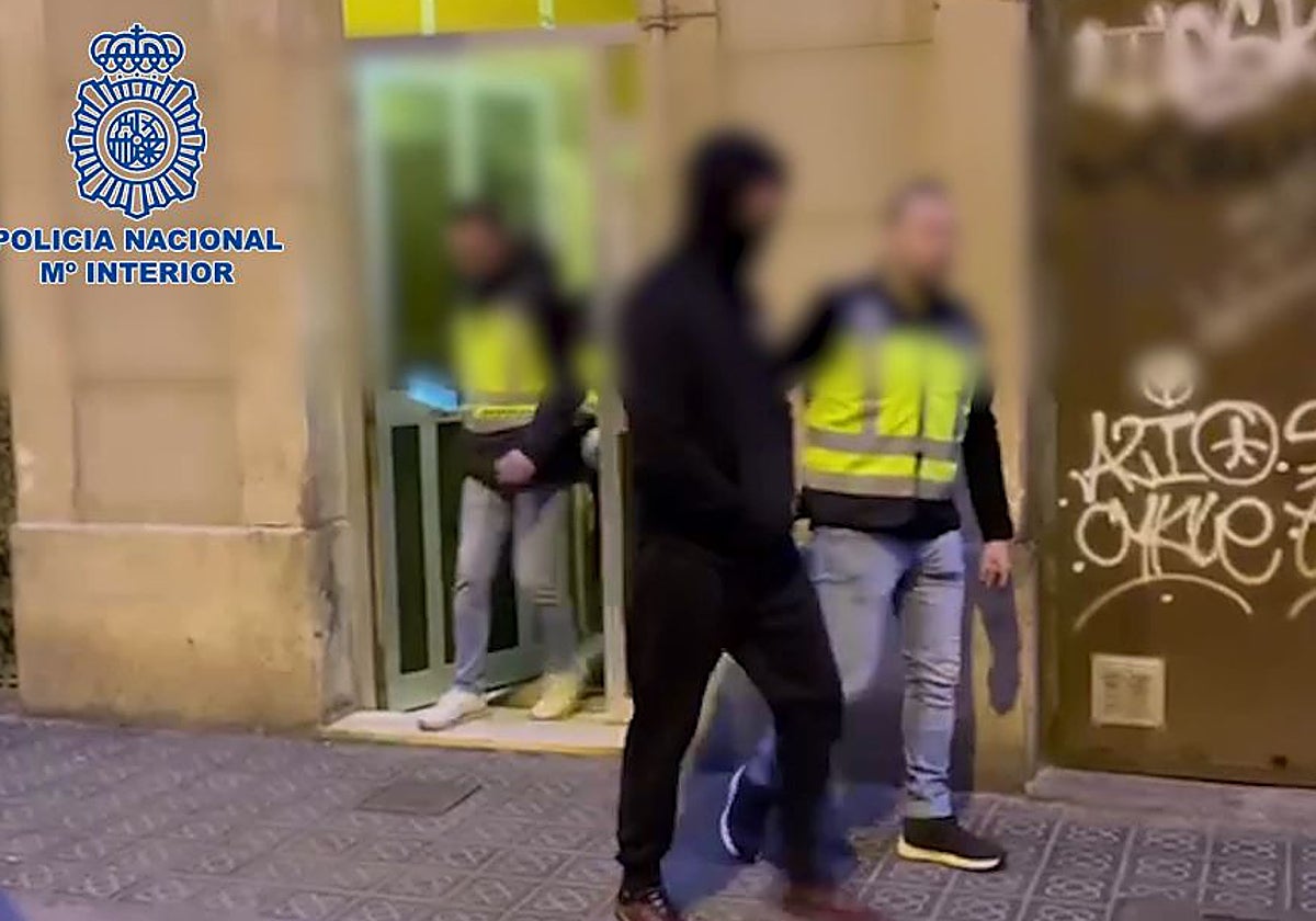 Agentes de la Policía Nacional conducen a uno de los detenidos