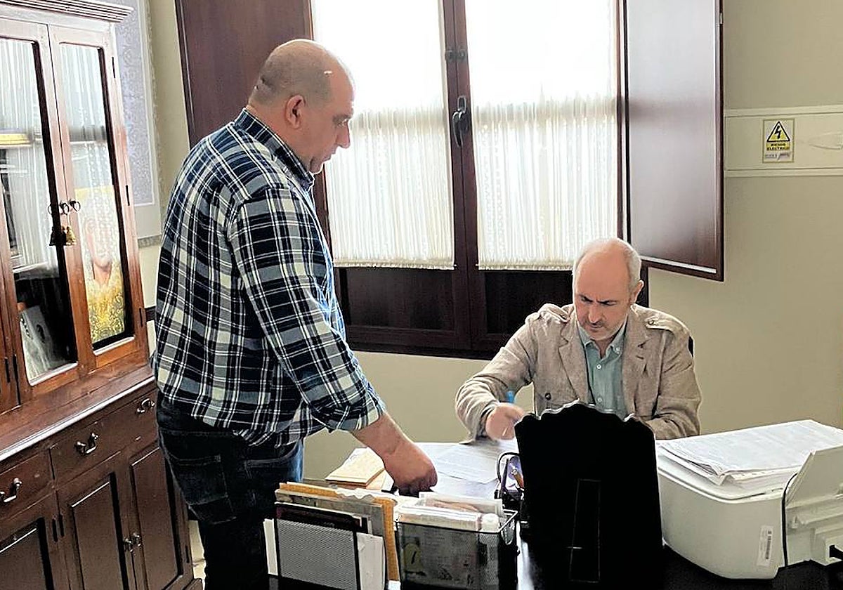 Manuel Solano, a la derecha, firma el contrato ante el hermano mayor, Manuel Hernández