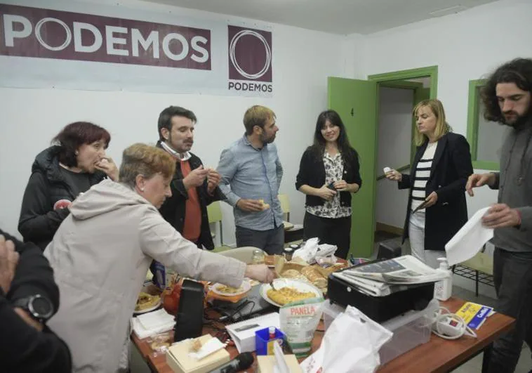 La candidata de Podemos a la Presidencia del Principado, Covadonga Tomé (c) y su equipo comen unas tortillas que militantes y amigos les llevaron a la sede durante el encierro que comenzó el jueves después de fracasar una reunión con la dirección regional del partido para solucionar las listas electorales a las elecciones en Asturias