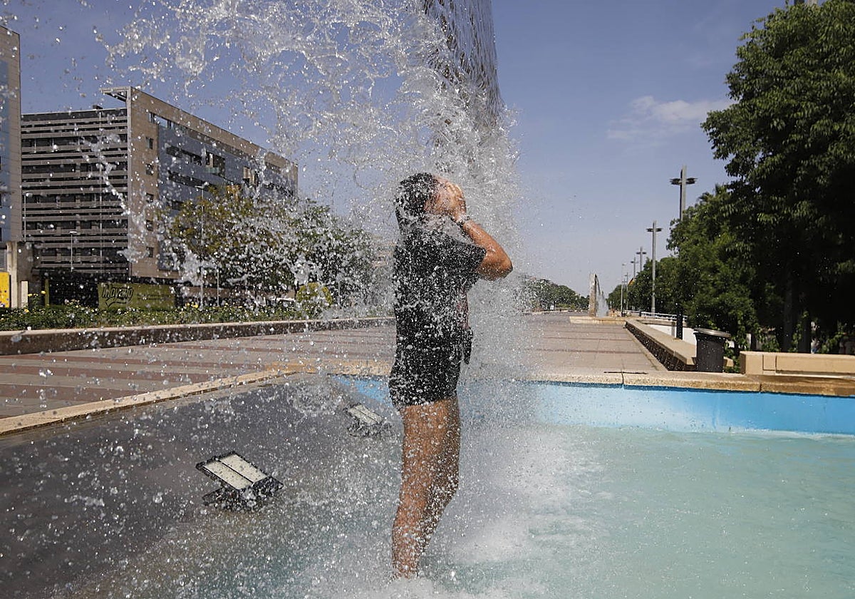Una joven se refresca en las fuentes del Vial Norte, este jueves