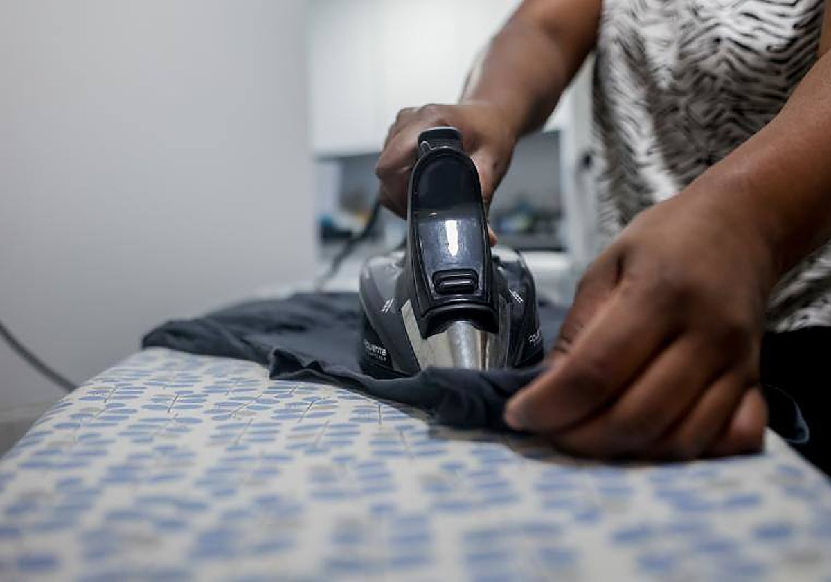 Una empleada del hogar realizando tareas de planchado