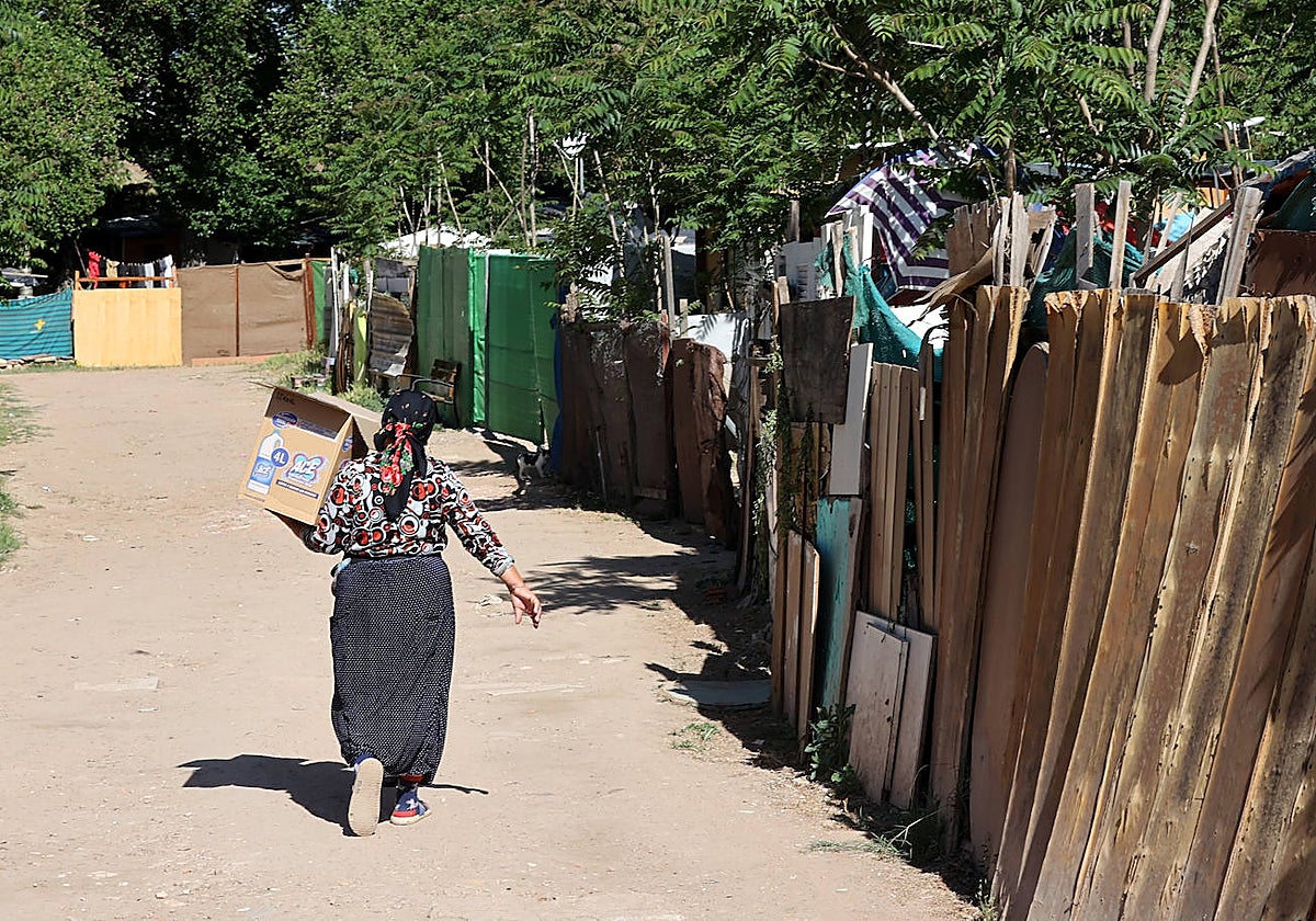 Una mujer recorre el poblado chabolista de camino de Carbonell