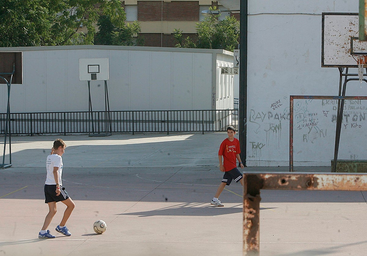 Dos niños juegan en el patio de un colegio