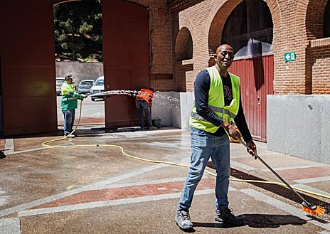 Imagen secundaria 1 - Un trabajador da los remates en el burladero de Las Ventas, mientras otros limpian e instalan las losetas nuevas en la puerta de arrastre y trabajan en las rejas y arcos del exterior