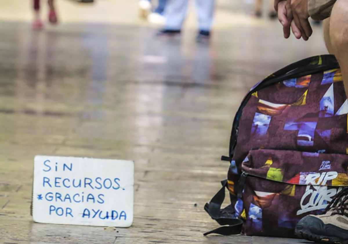 Una persona muestra un cartel pidiendo ayuda en foto recurso