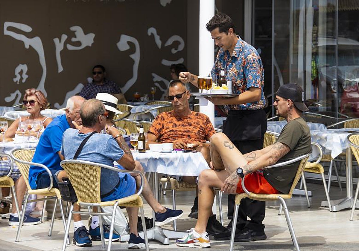 Imagen de archivo de un camarero sirviendo consumiciones en un bar de Benidorm