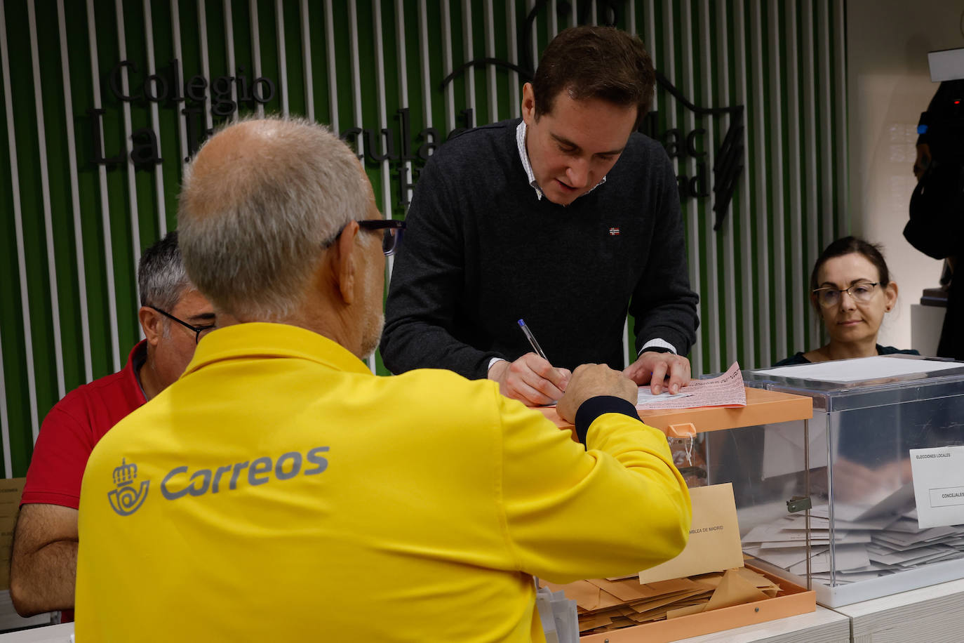 Un trabajador de mensajería entrega los votos por correo en el colegio electoral de Inmaculada Marillac en Madrid este domingo durante las elecciones municipales y autonómicas