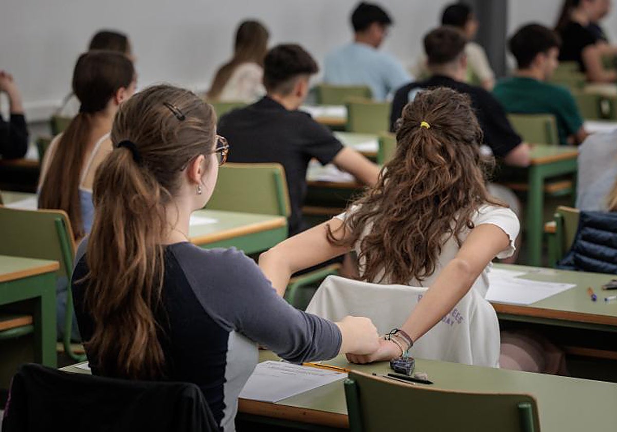 Dos estudiantes se estrechan las manos al empezar el examen de la PAU en Valencia, este martes