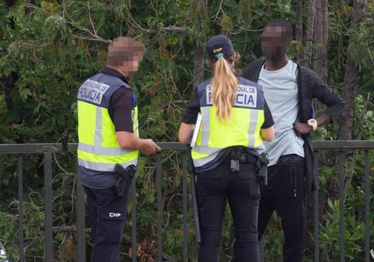 Dos agentes identifican a un inmigrante en la frontera entre España y Francia