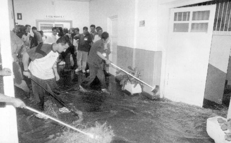 Imagen principal - Arriba, operarios achicando agua en el Estadio Santiago Bernabéu, donde se inundaron hasta los vestuarios. Abajo, izq., estado en que quedó la M-30 al día siguiente de las tormentas. Dcha, la grúa se lleva uno de los vehículos afectados por la inundación. 