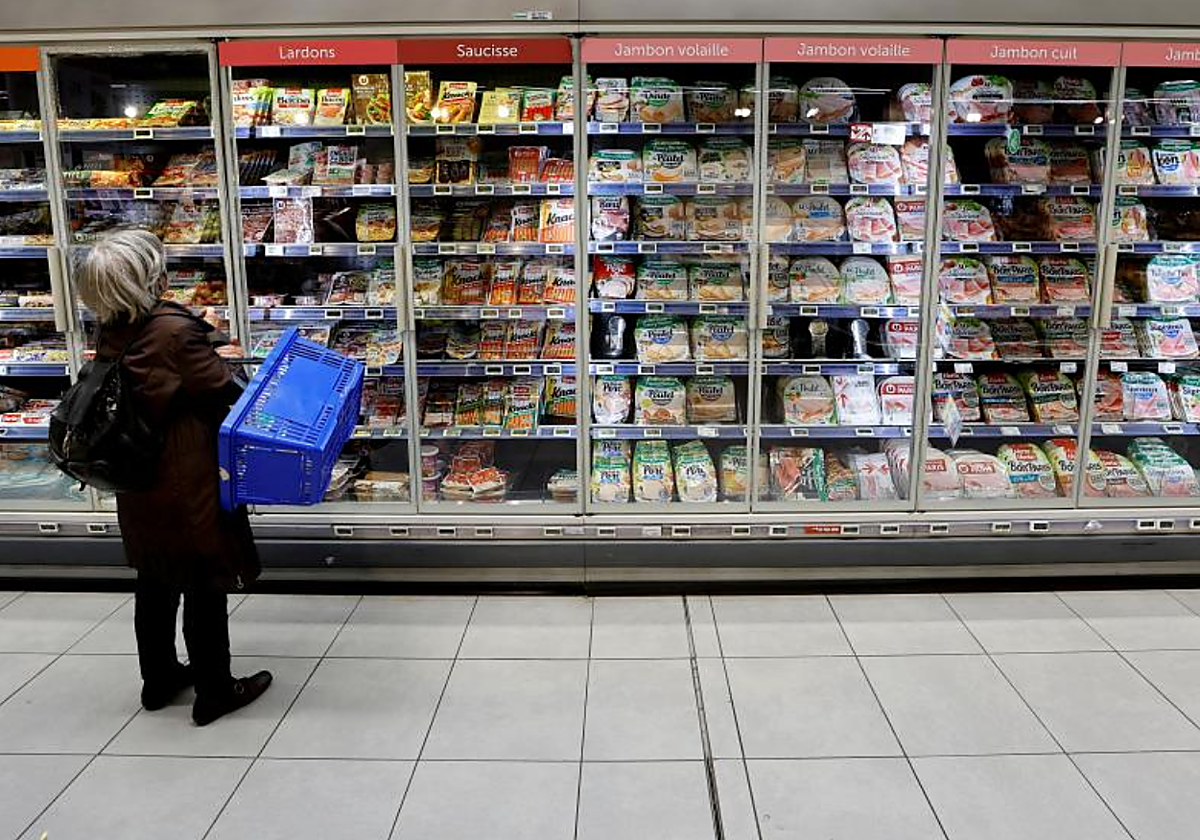 Una mujer compra en un supermercado en foto de archivo