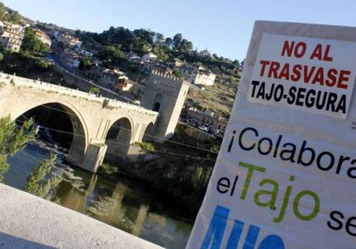 Cartel de una manifestación contra los trasvases del Tajo al Segura junto al cauce del río en Toledo