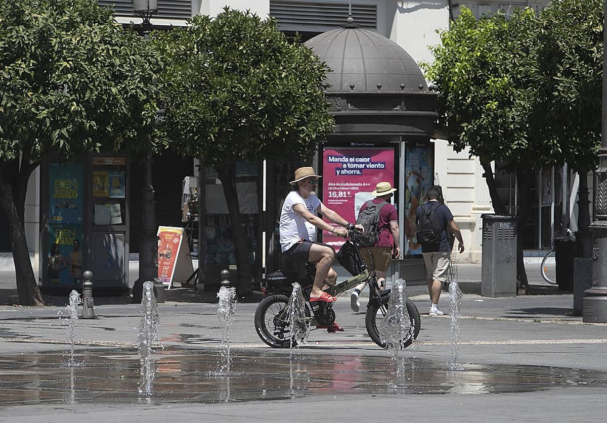 Un ciclista pasea bajo el sol por la plaza de las Tendillas de Córdoba