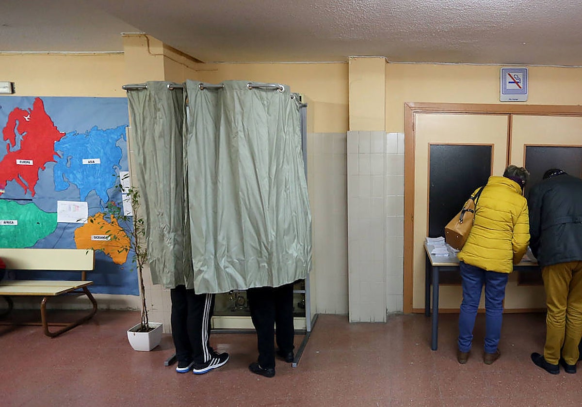 Varias personas preparan su voto en un colegio electoral de Valladolid, en las generales de 2019