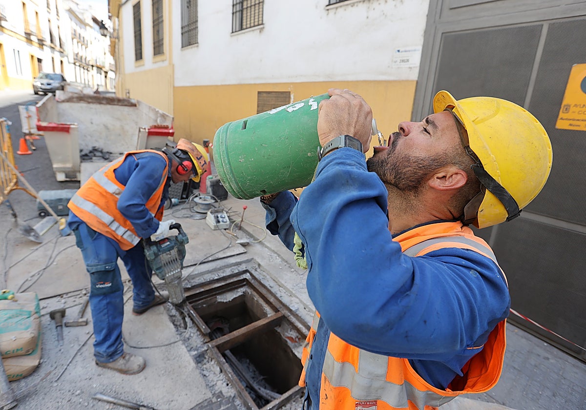 Un trabajador se refresca en una obra del centro de la ciudad