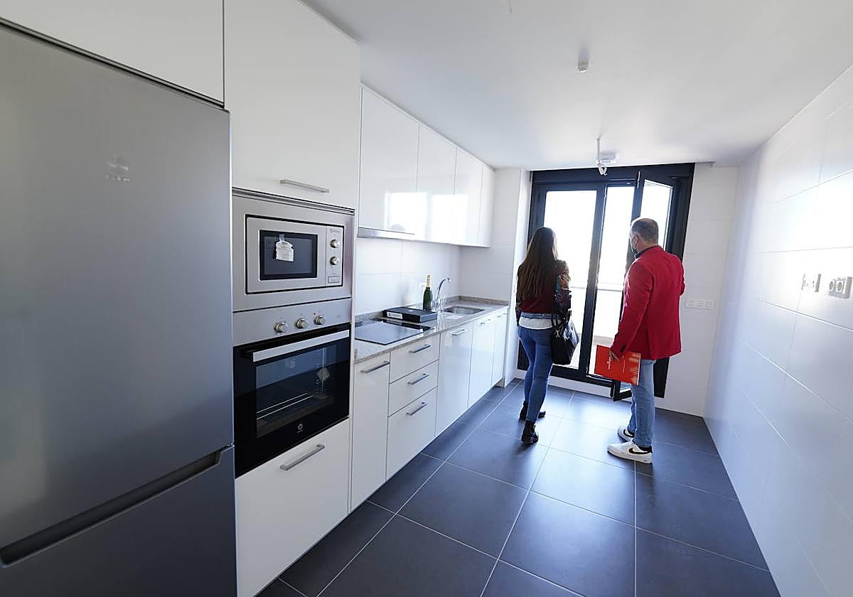 Un trabajador de una inmobiliaria enseña un piso a una cluente