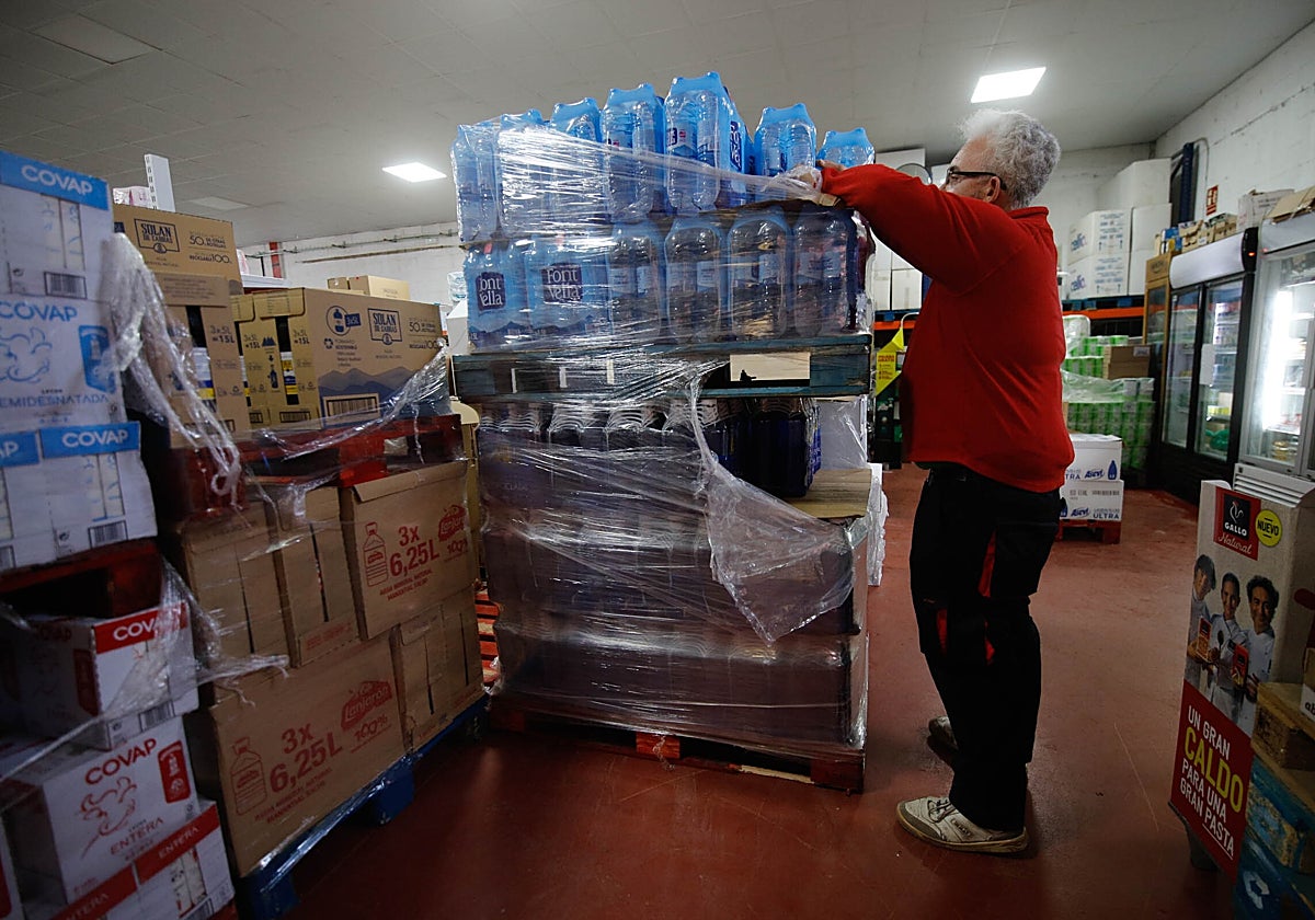 Un comerciante acopia agua potable en la trastienda del establecimiento
