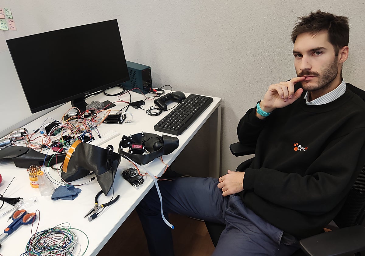 Eduardo Fuentevilla, cofundador de Maedcore, posa junto a los componentes de su perro robot