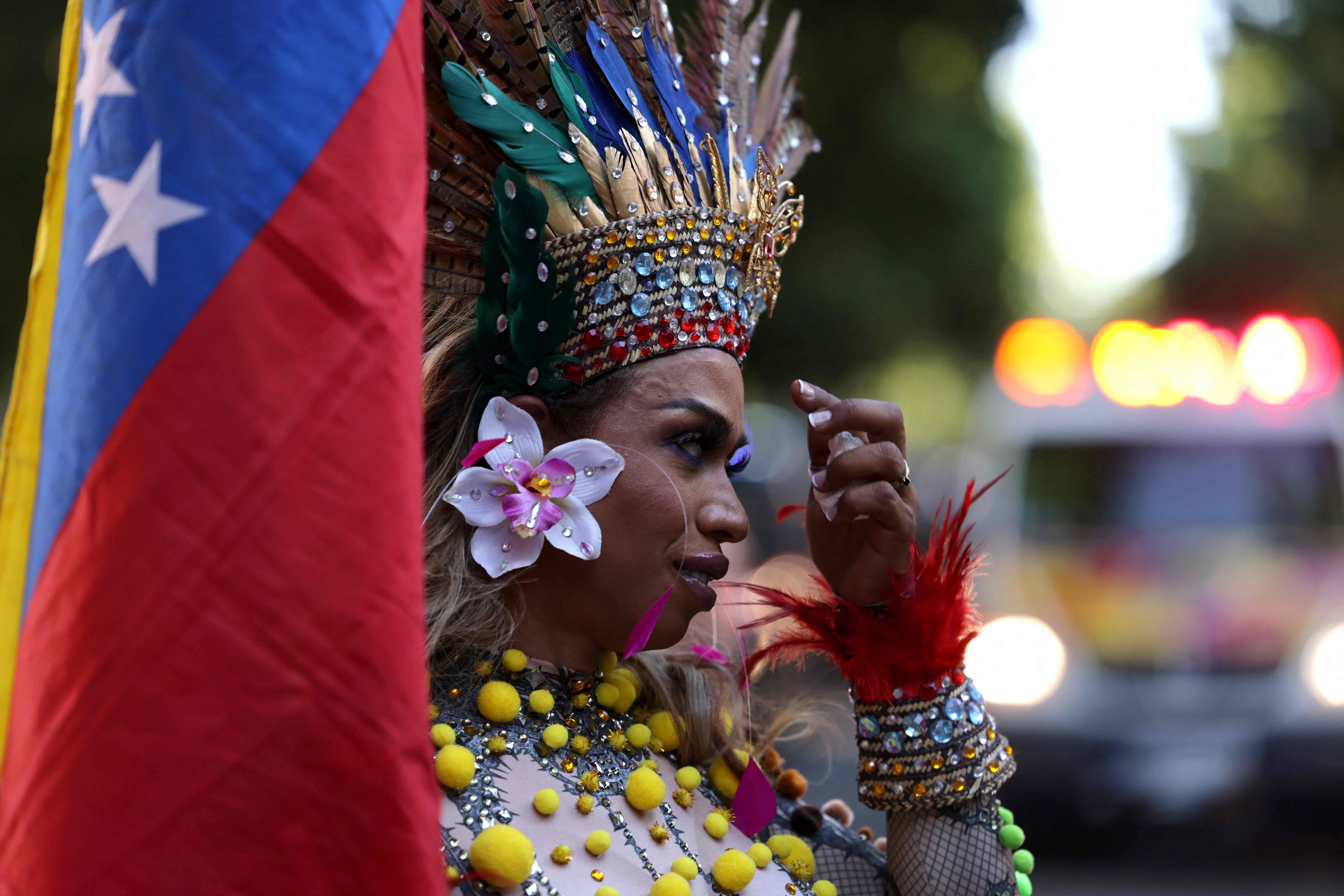 Una participante lleva la bandera de Venezuela durante la manifestación
