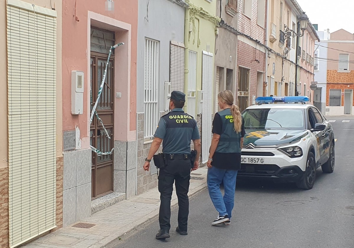 Dos guardias civiles frente a una de las viviendas desalojadas por el incendio