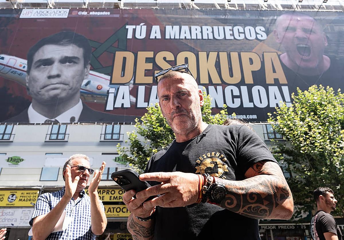 El jefe de Desokupa con la lona gigante desplegada por su empresa en Atocha, 75, Madrid